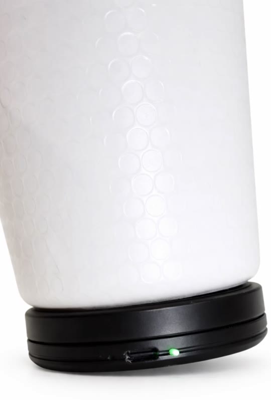 The Sponge Clip fitted around the base of a white water bottle, its status light lit green